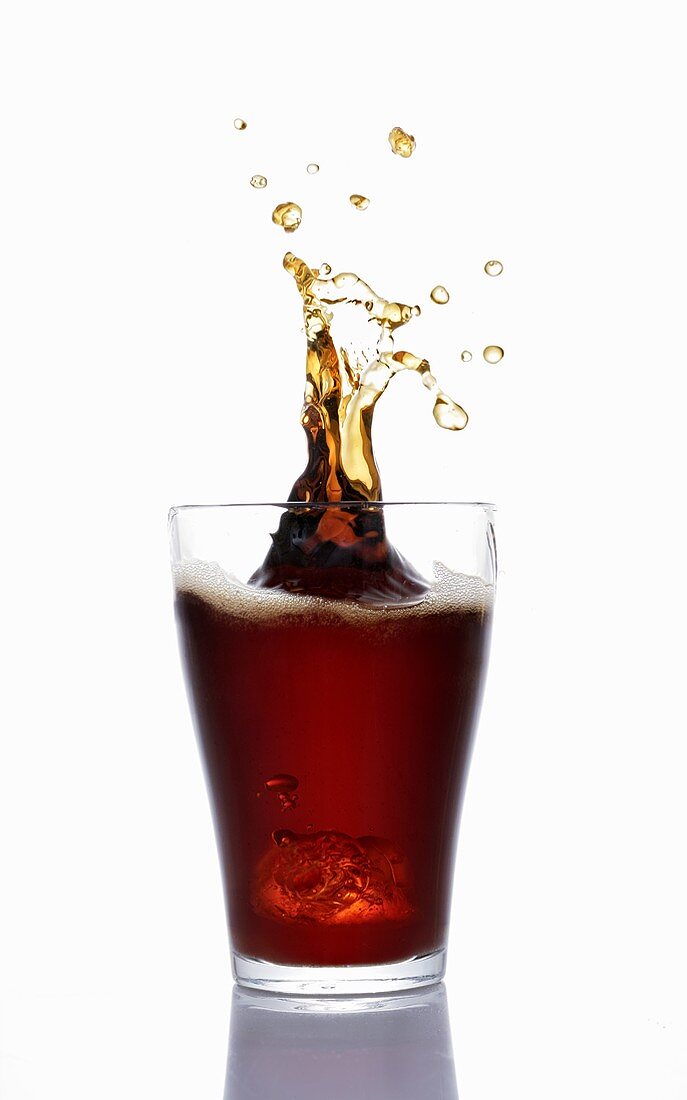 Cola spritzt aus dem Glas