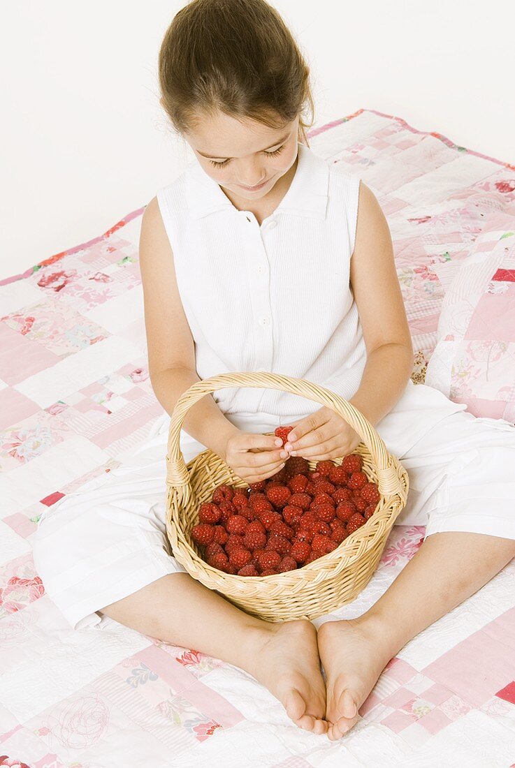 Girl with a basket of raspberries