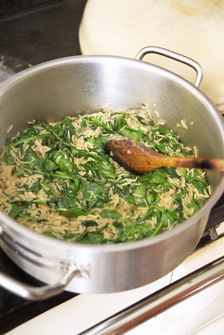 Making spinach soup: sweating the spinach with rice