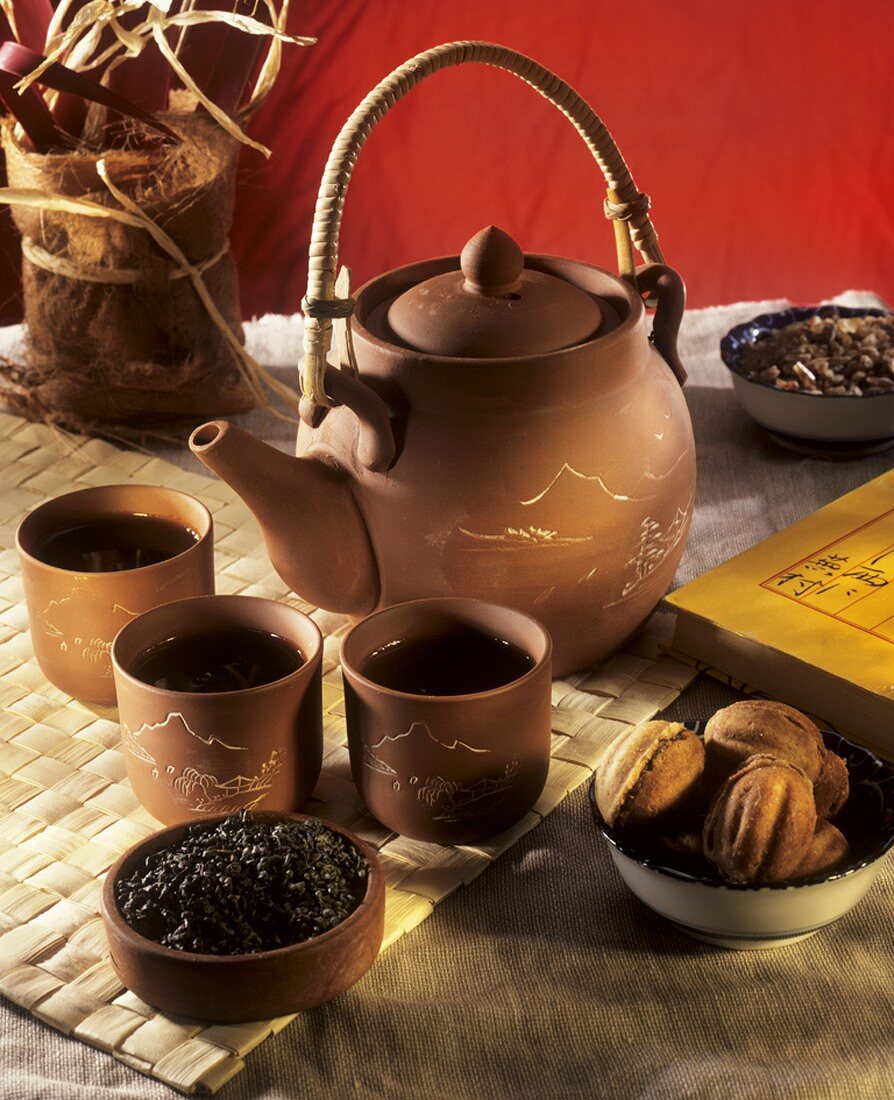 Grüner Tee in asiatischem Teegeschirr, daneben Gebäck
