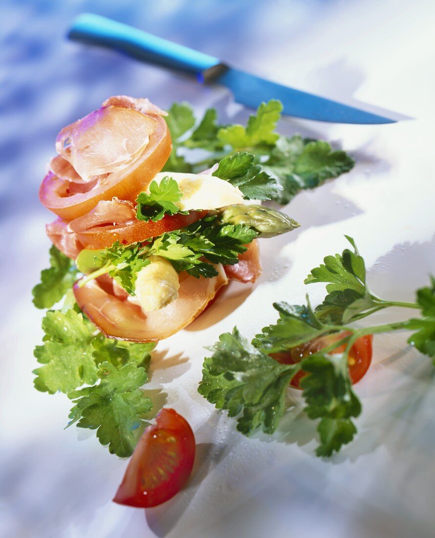 Asparagus with tomatoes, ham and parsley