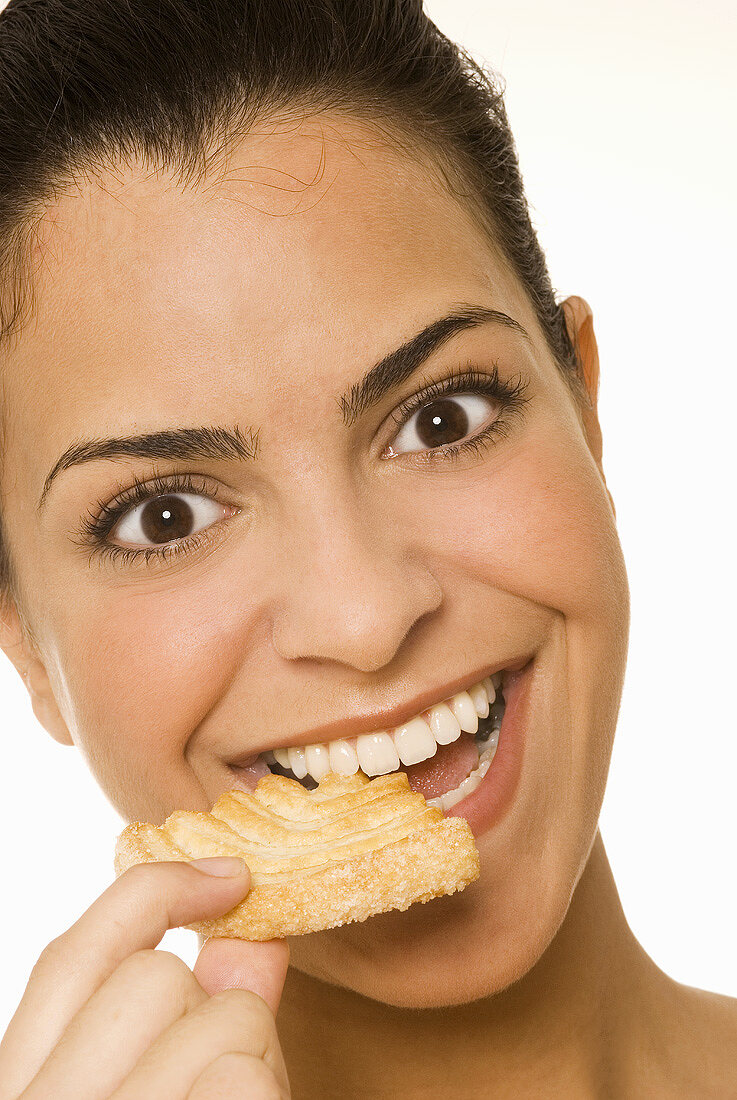 Young woman eating a sweet pastry