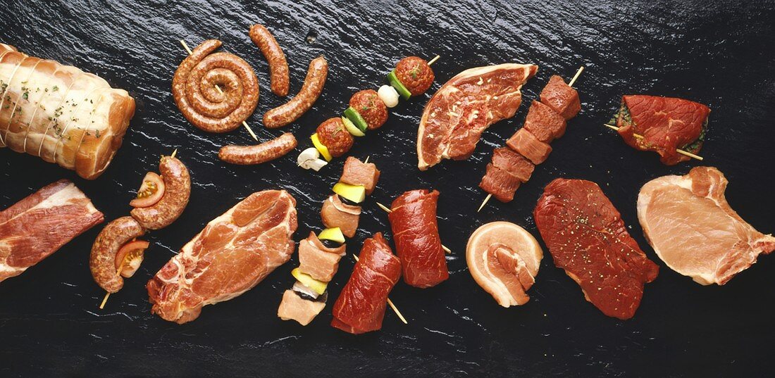 Assorted meats and sausages on hot stone grill