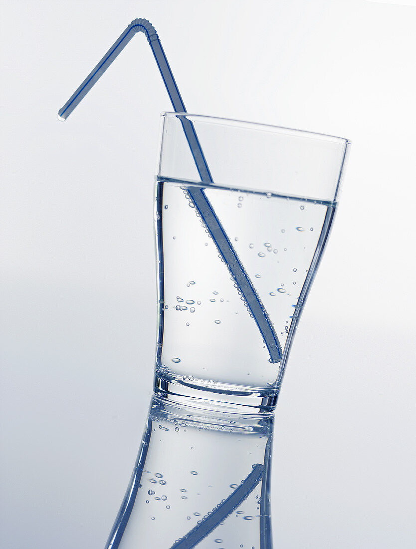 A glass of mineral water with straw