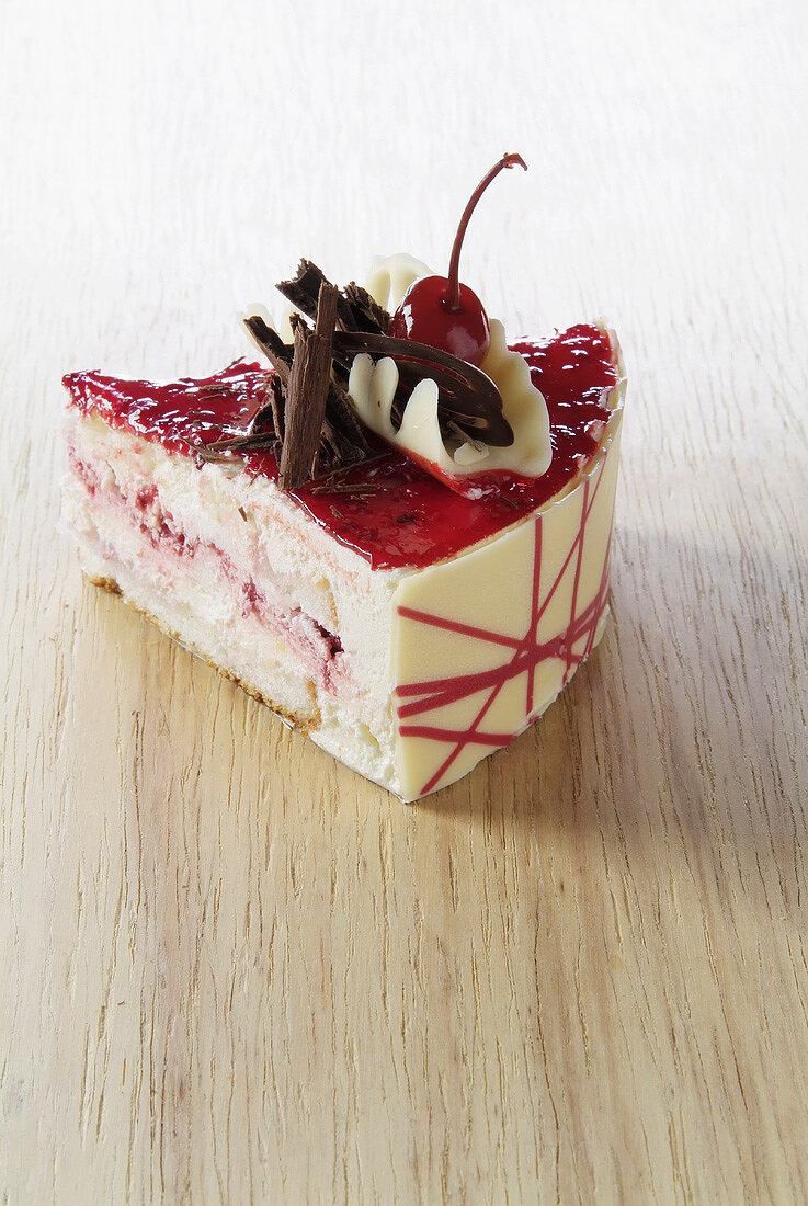 A piece of cherry cheesecake with chocolate shavings
