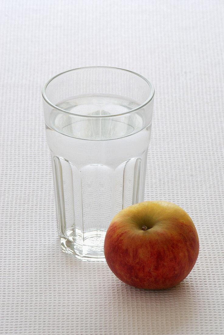 A glass of water and an apple