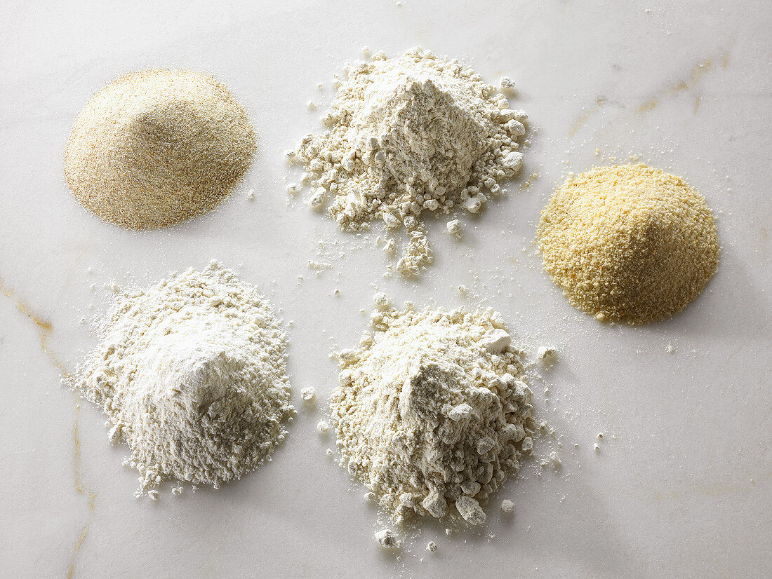 Different types of organic flour on a marble slab