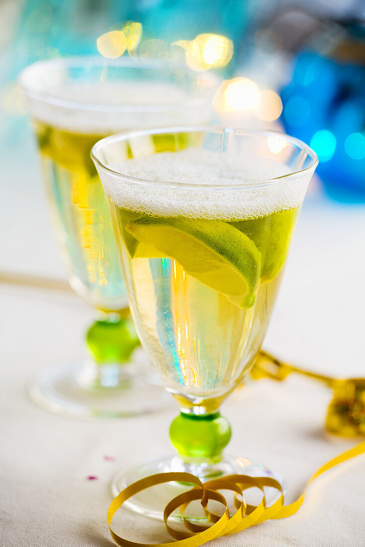 Two glasses of sparkling wine with lemon wedges