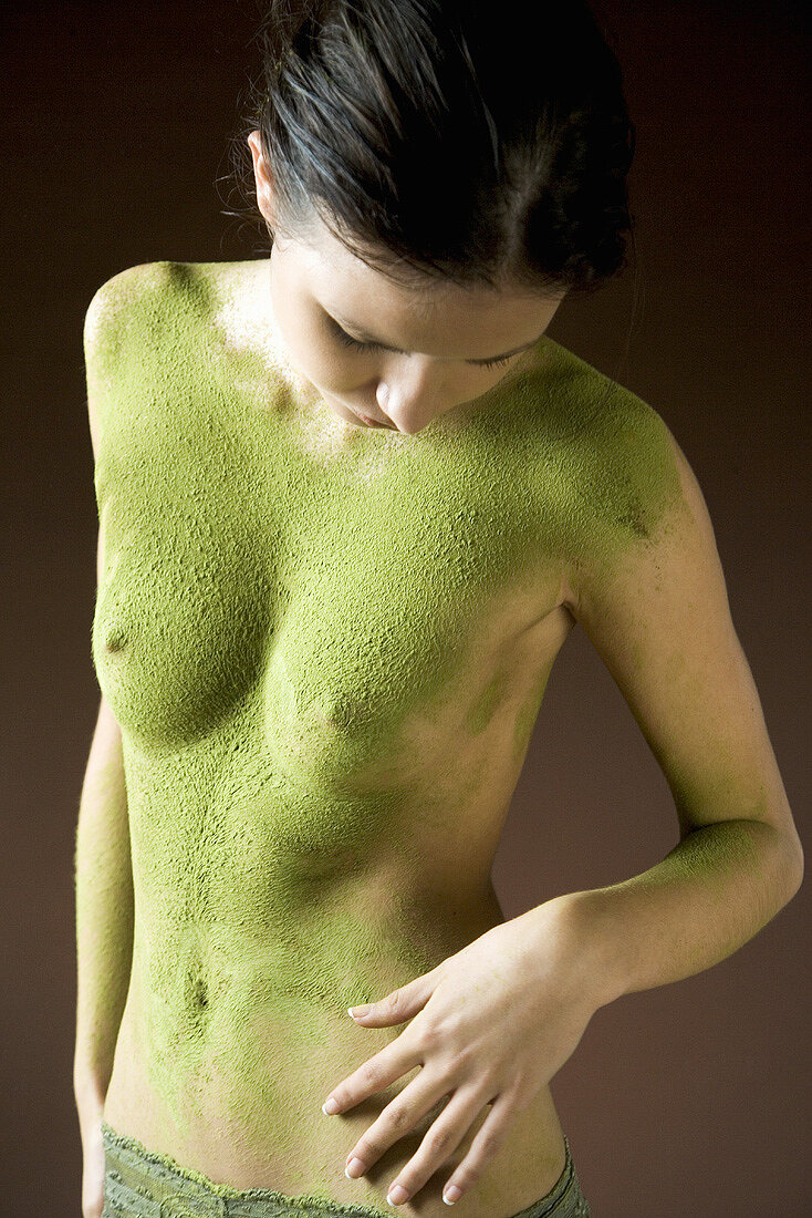 Junge Frau mit Körpermaske aus grünem Tee