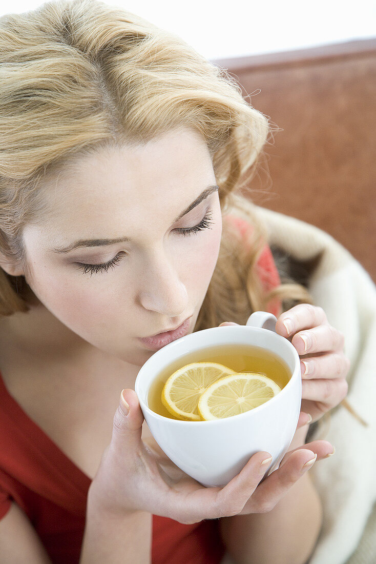 Young woman drinking lemon tea
