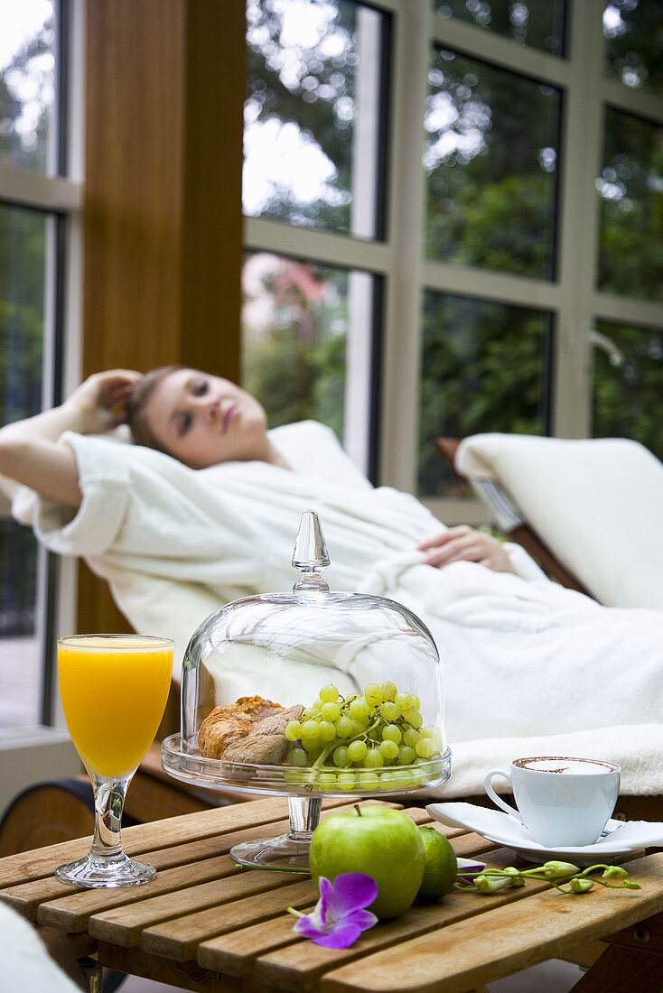 Young woman with small breakfast at swimming pool