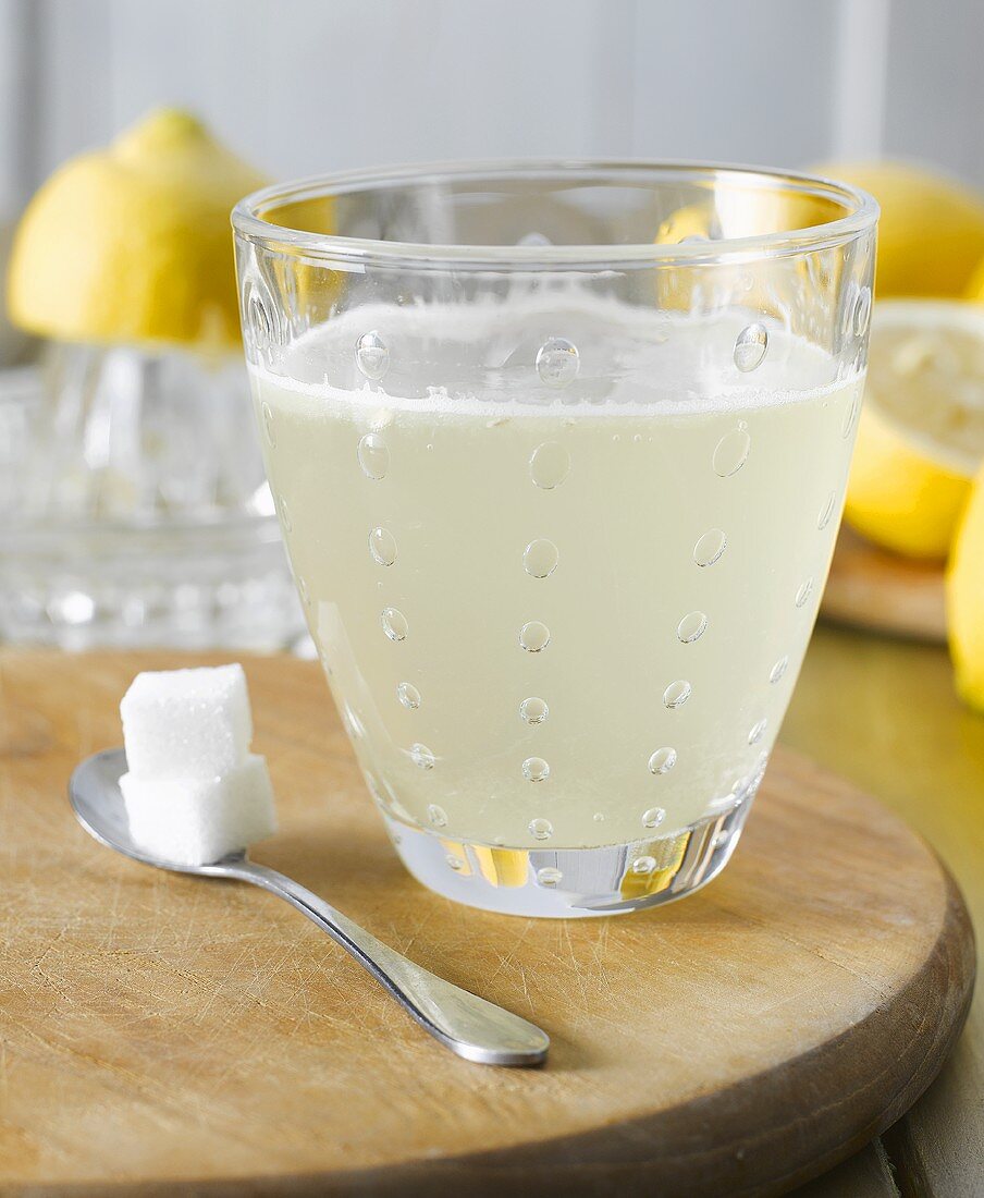 Hot lemon with sugar cubes, lemons in background