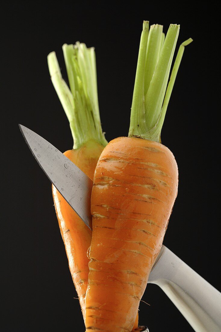 Eine Karotte mit Messer durchschneiden