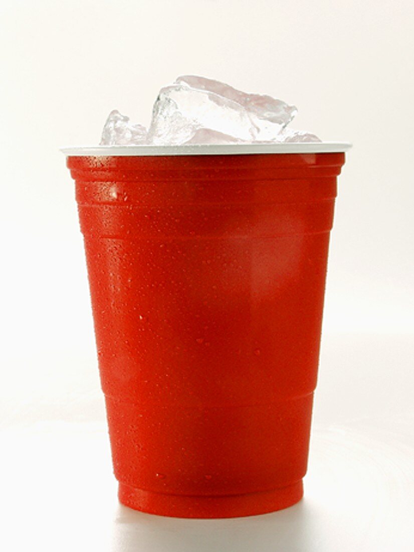 Roter Plastikbecher mit Eiswürfeln