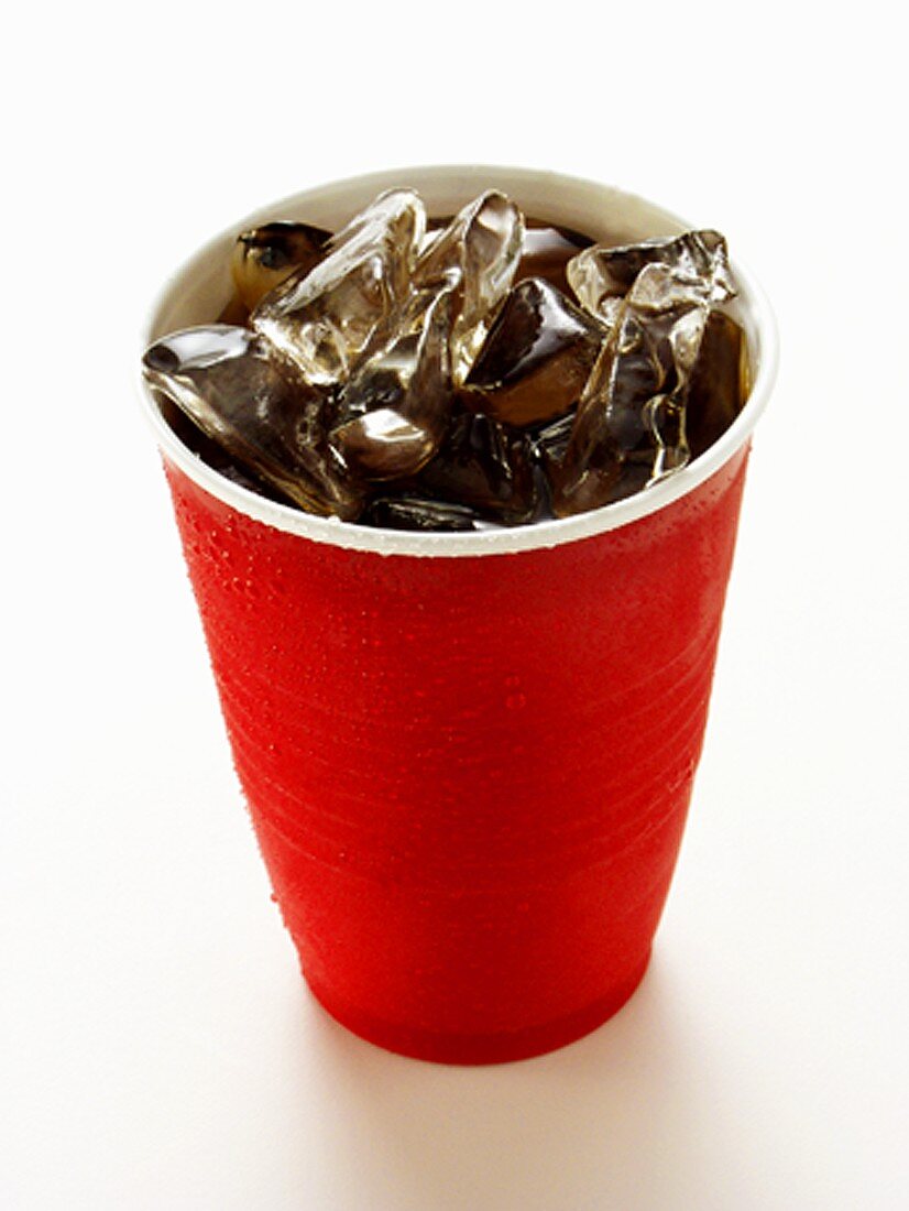 Cola mit Eiswürfeln im roten Plastikbecher