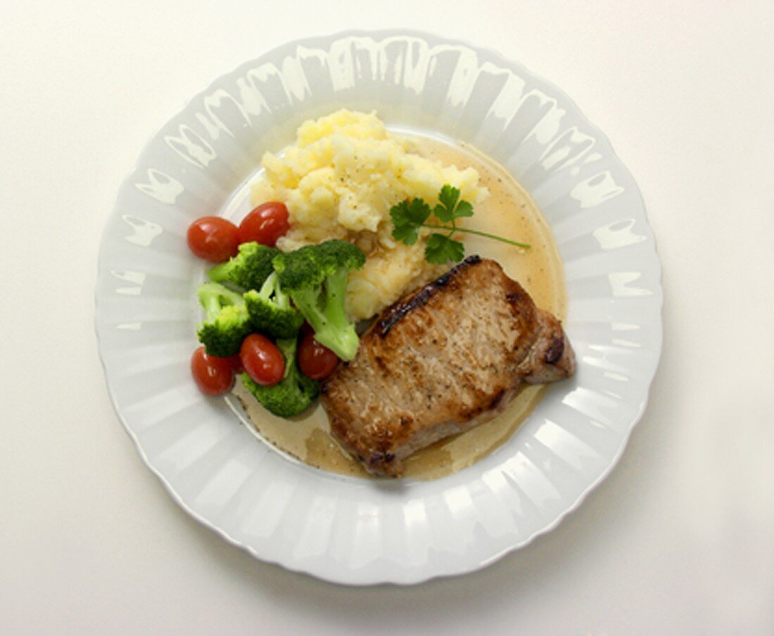 Schweinekotelett mit Kartoffelpüree, Brokkoli und Tomaten