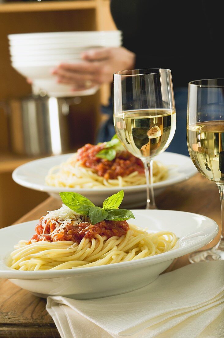 Spaghetti bolognese and white wine for two on table