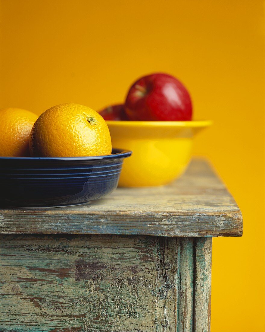 Zwei Ostschalen mit Orangen und Äpfeln auf einem Tisch