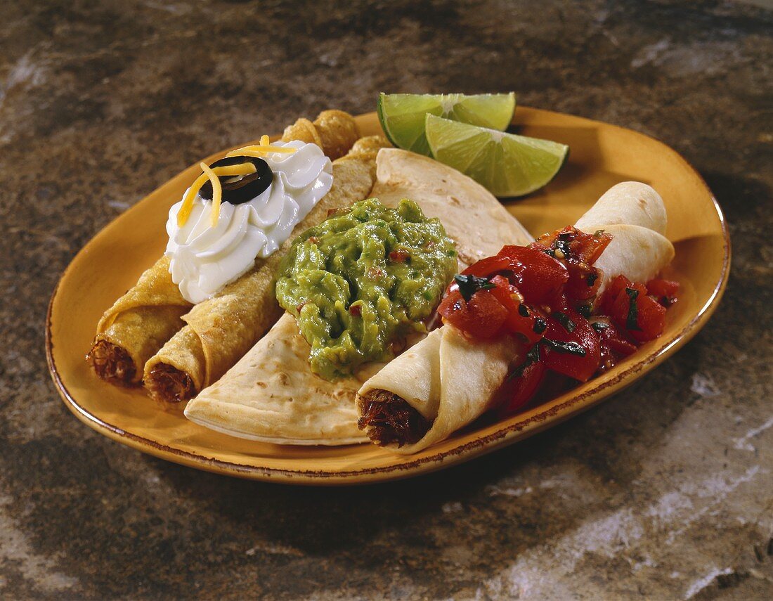 Enchilada, Taquitos und Quesadilla auf einem Teller