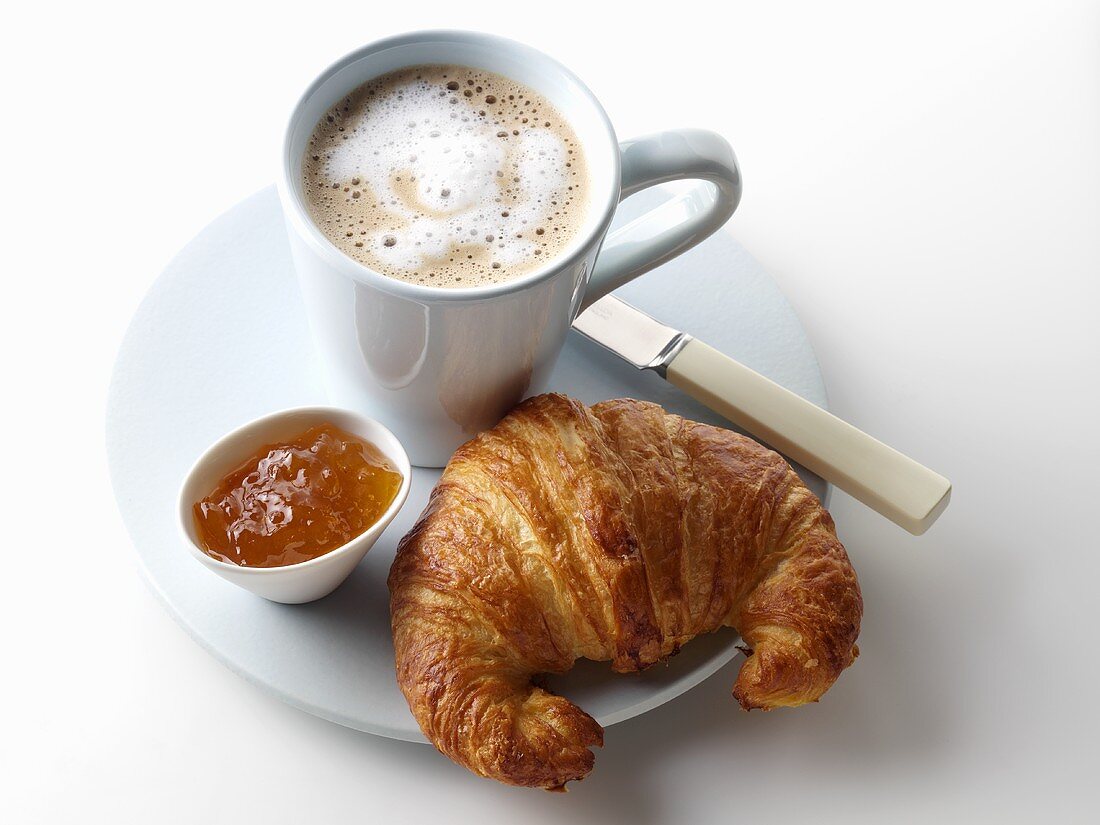 Croissant mit Marmelade und eine Tasse Kaffee