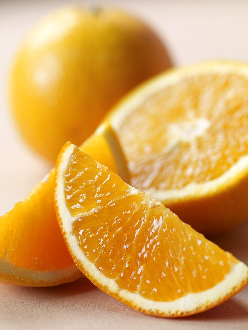 Orangenspalten, eine Orangenhälfte und eine ganze Orange