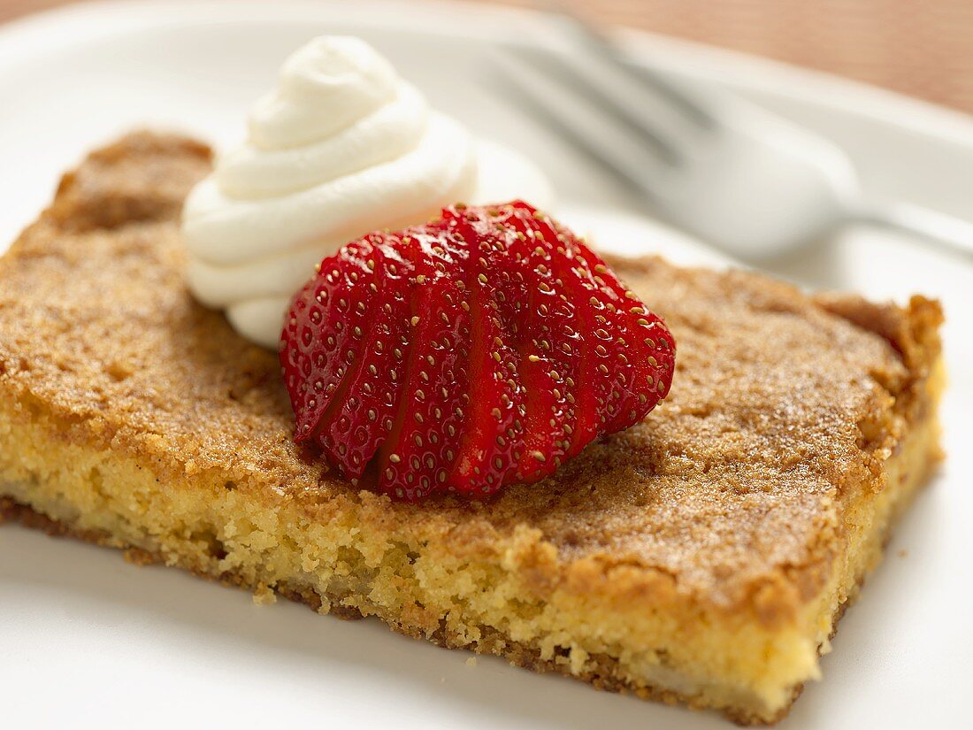 Maisbrotschnitte mit Sahnetupfen und Erdbeere