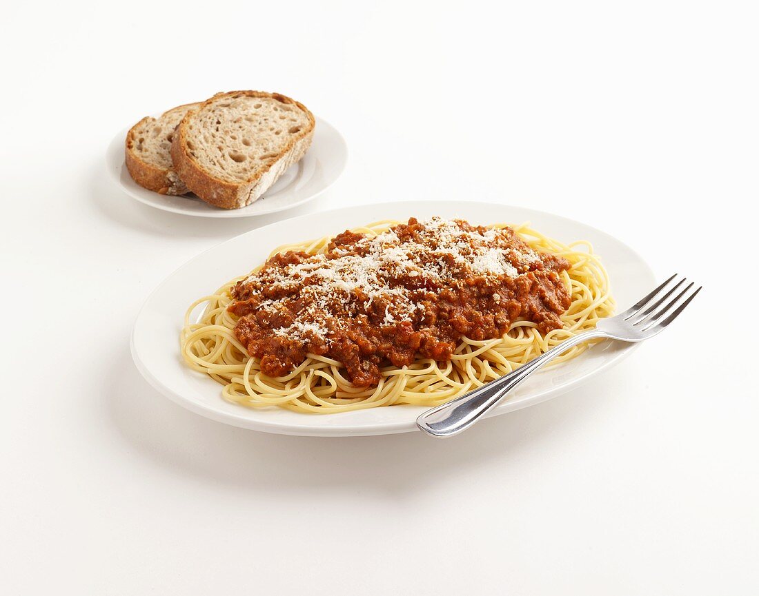 Spaghetti mit Hackfleischsauce, zwei Brotscheiben