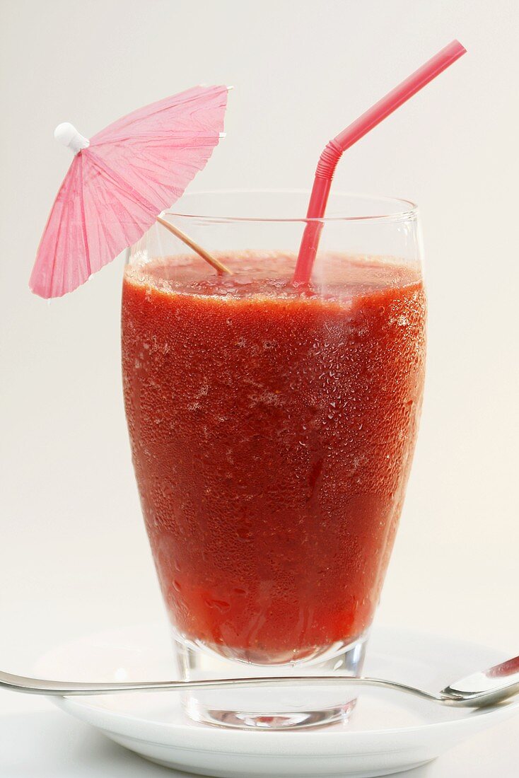 A frozen strawberry daiquiri with a cocktail umbrella