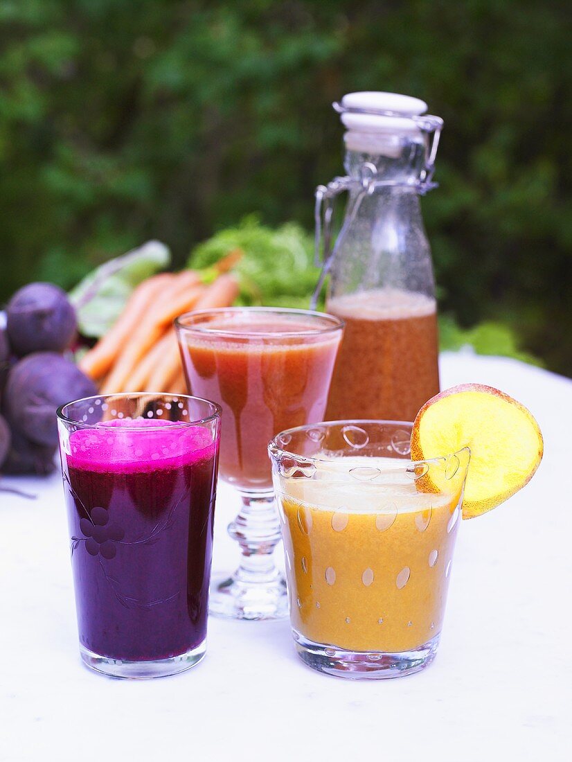 Verschiedene Smoothies auf Gartentisch