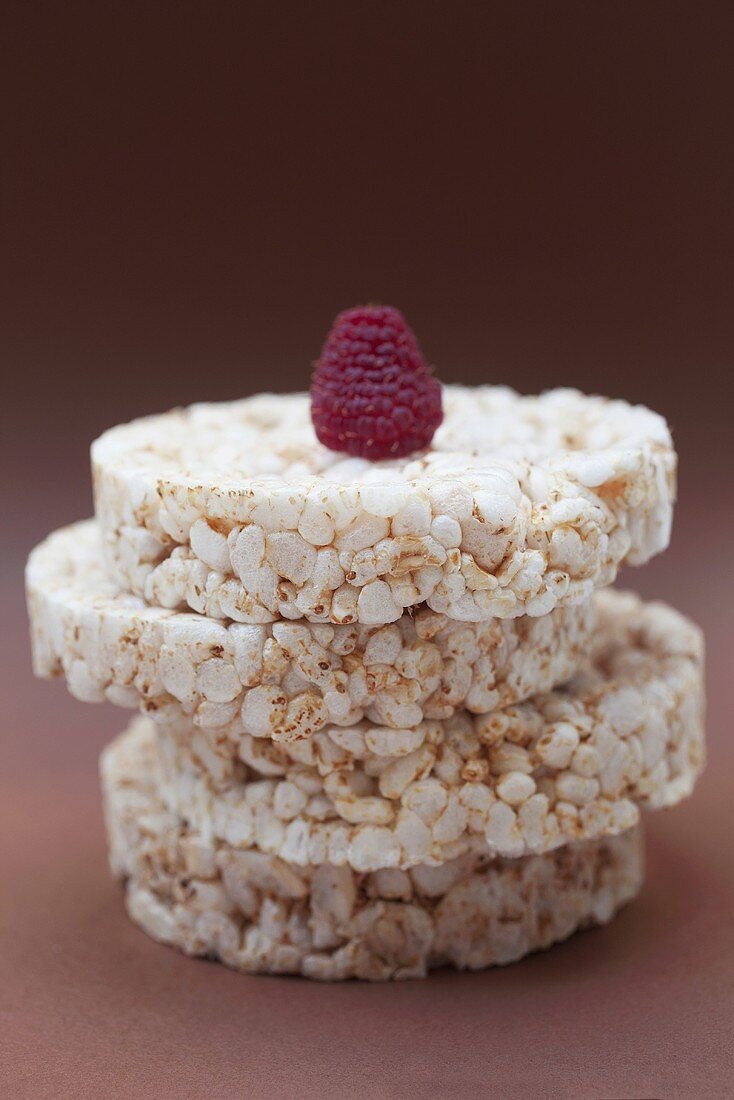 A raspberry on top of a stack of rice cakes