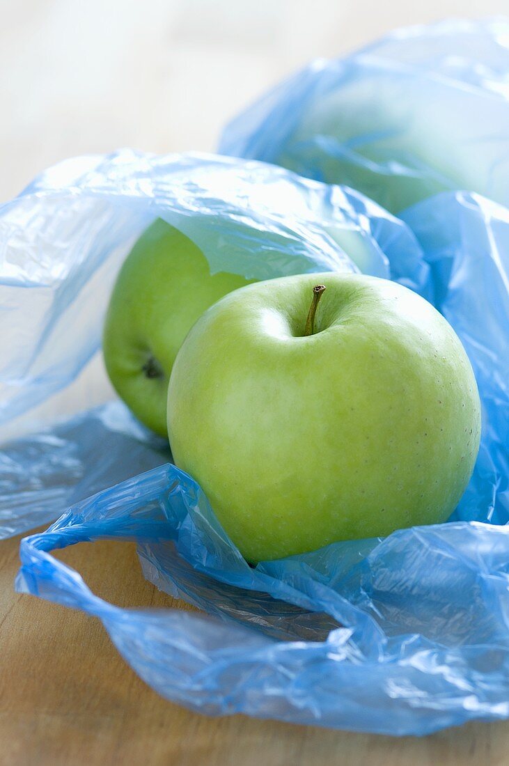 Green apples in plastic bags