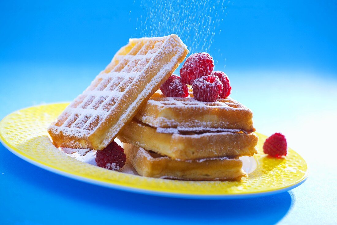 Waffles with raspberries and icing sugar