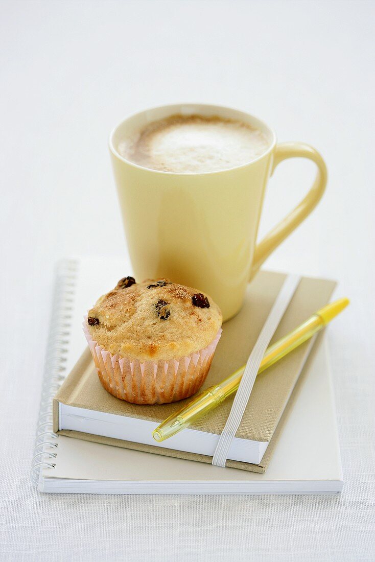 A raisin muffin with a cafe au lait