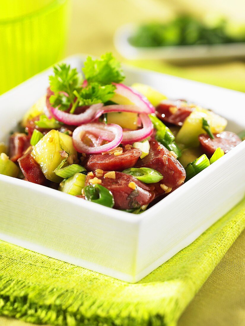 Cucumber salad with sausage and onion