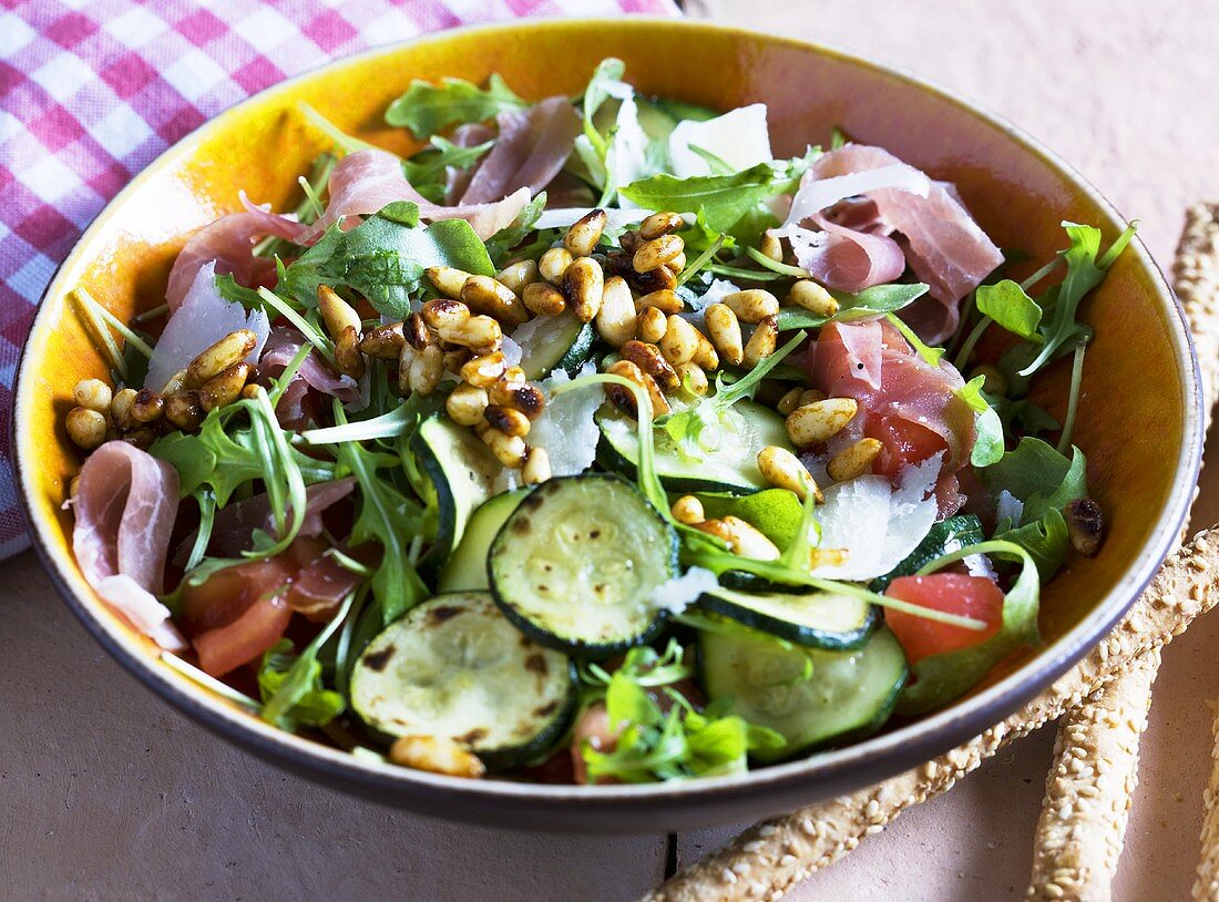 Blattsalat mit Zucchini, Rohschinken und Pinienkernen