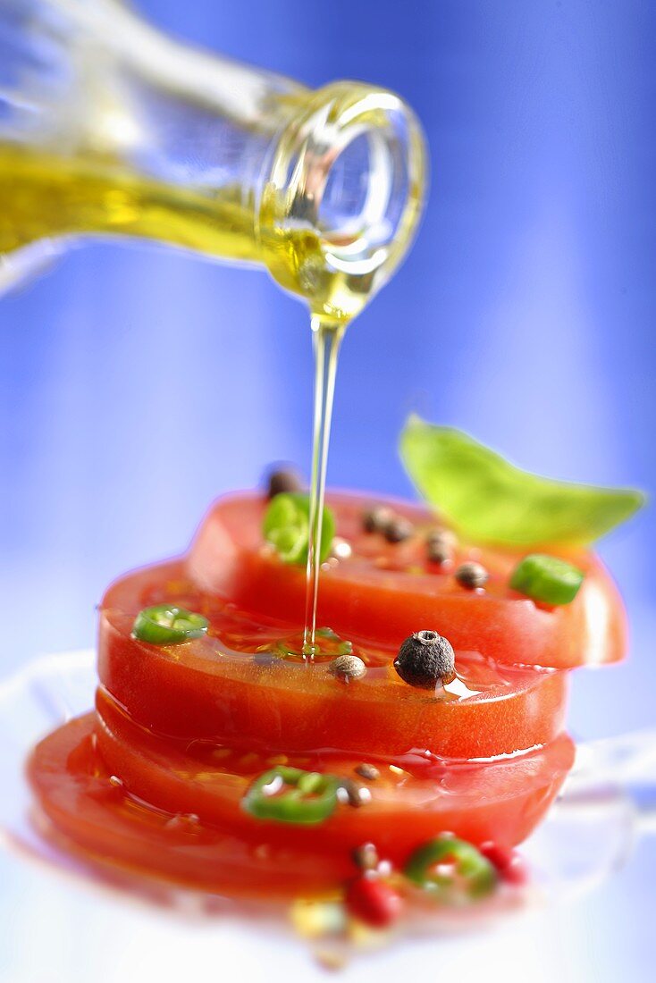 Spiced tomatoes being drizzled with olive oil