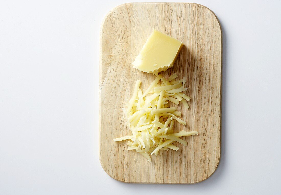 Gruyere, partially grated, on a chopping board