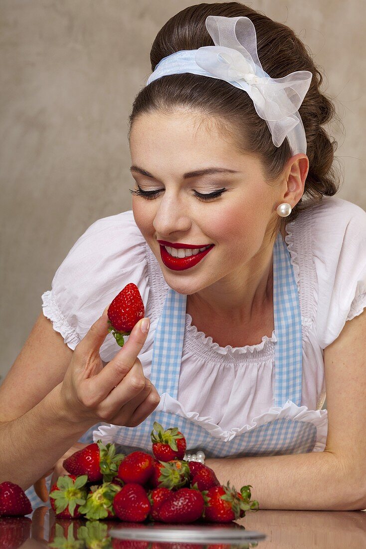 A retro-style girl eating fresh strawberries