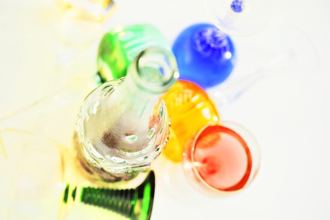 A bottle and glasses filled with coloured liquids