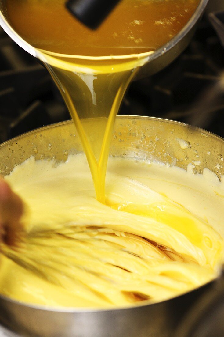 Sauce Hollandaise being prepared: adding clarified butter
