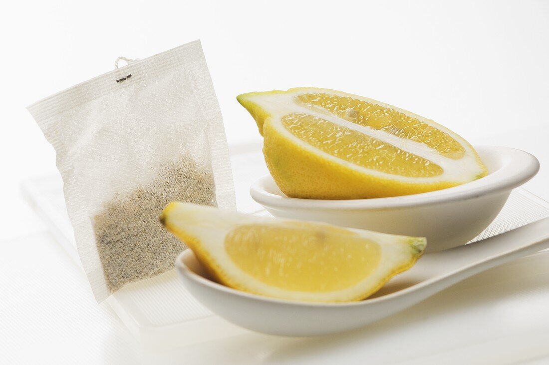 A lemon wedge, half a lemon and a tea bag