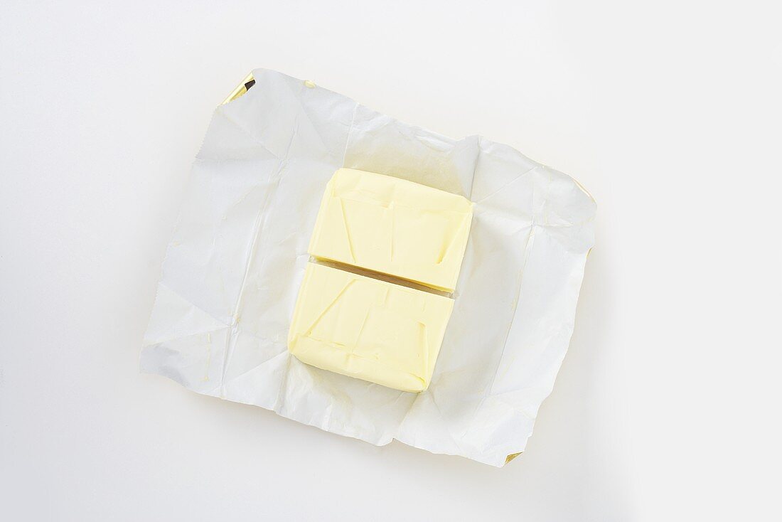 A pat of butter, halved, on paper
