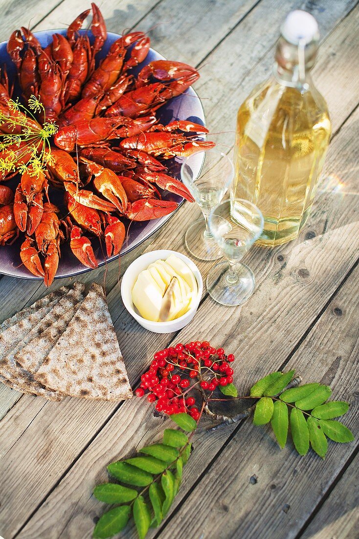 Cook crayfish, crisp breads, butter and wine on a wooden table