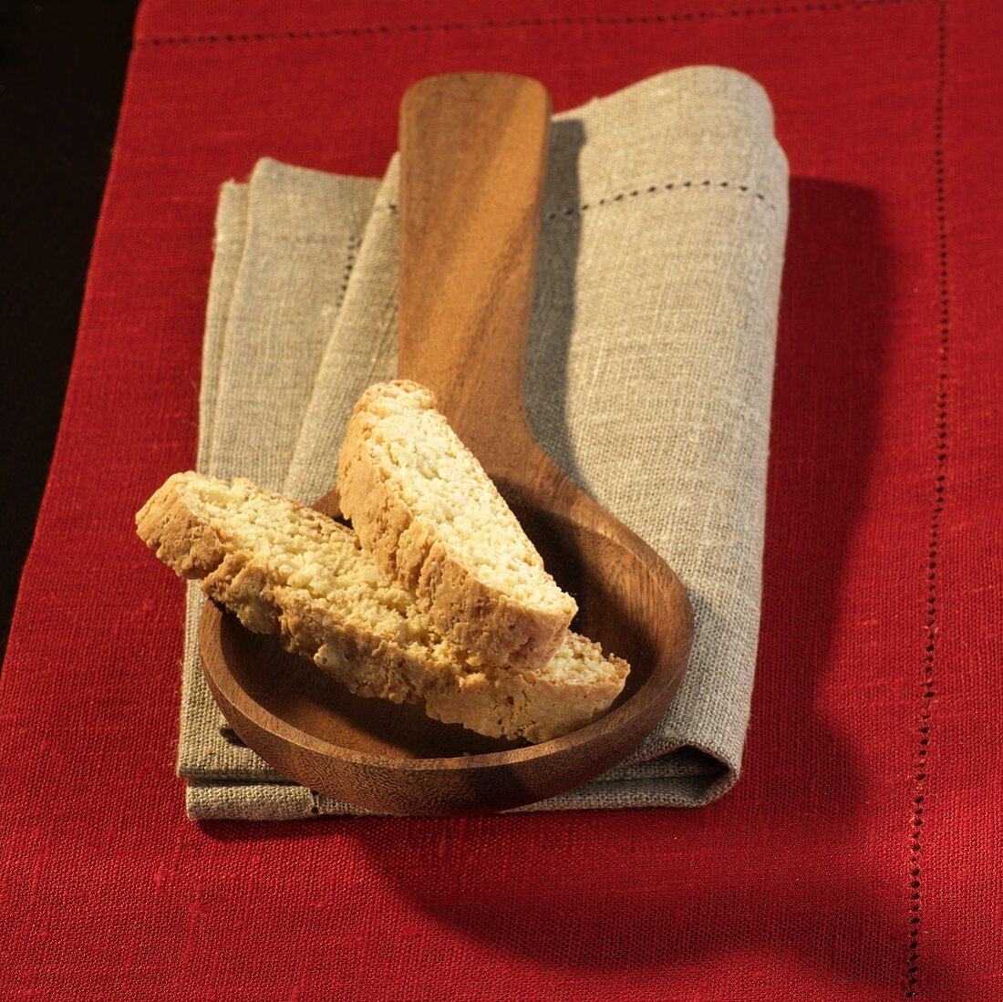 Cantucci on a wooden spoon on a linen cloth