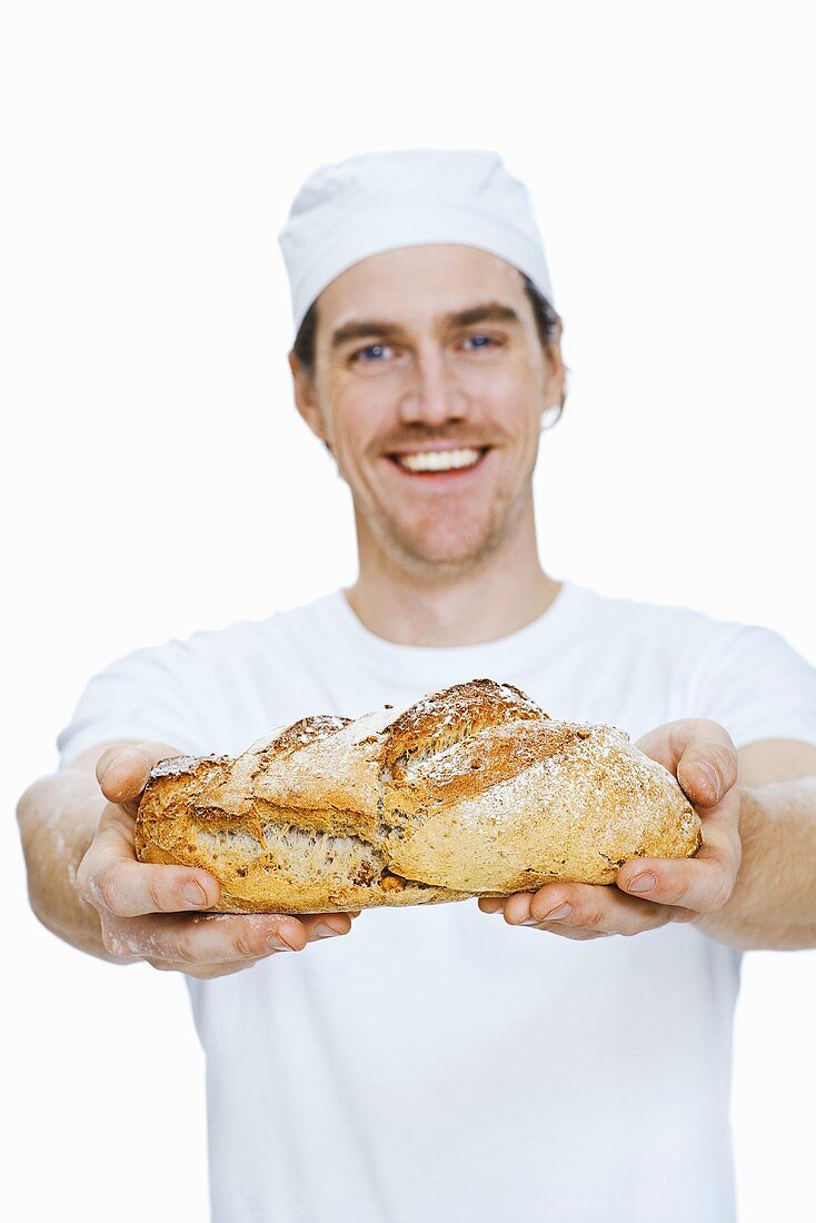A backer holding freshly baked white bread