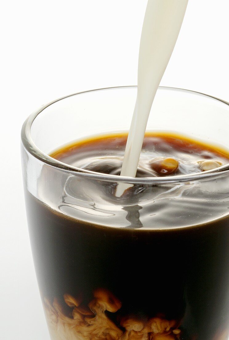 Cream being poured into coffee