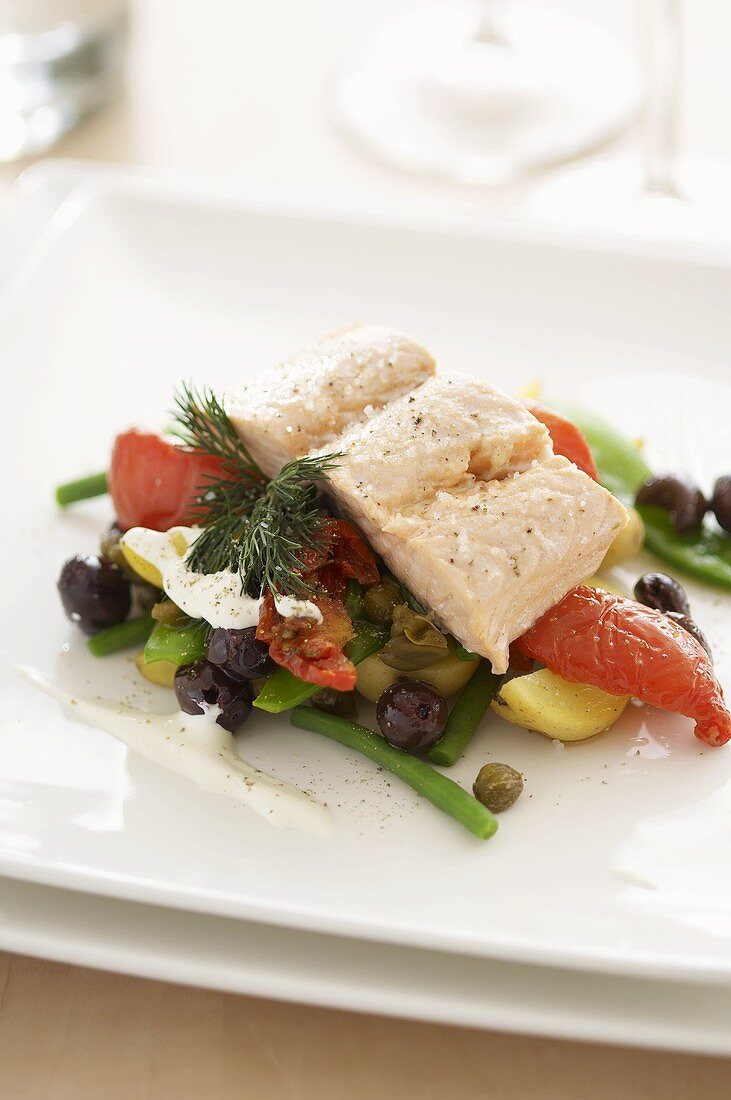 Salmon fillet on a bed of summer vegetables (tomatoes, olives, green beans)