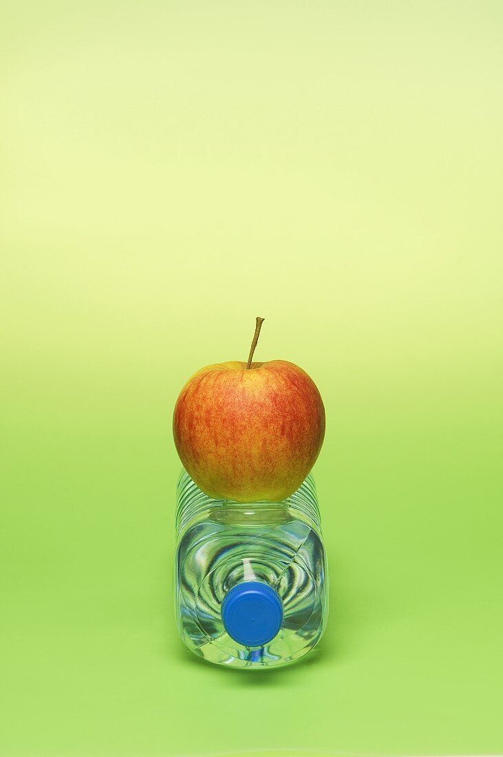 An apple on a bottle of water