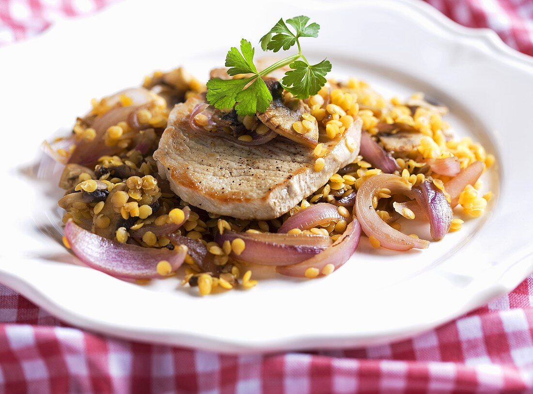 Schweinekotelett mit Linsen und roten Zwiebeln