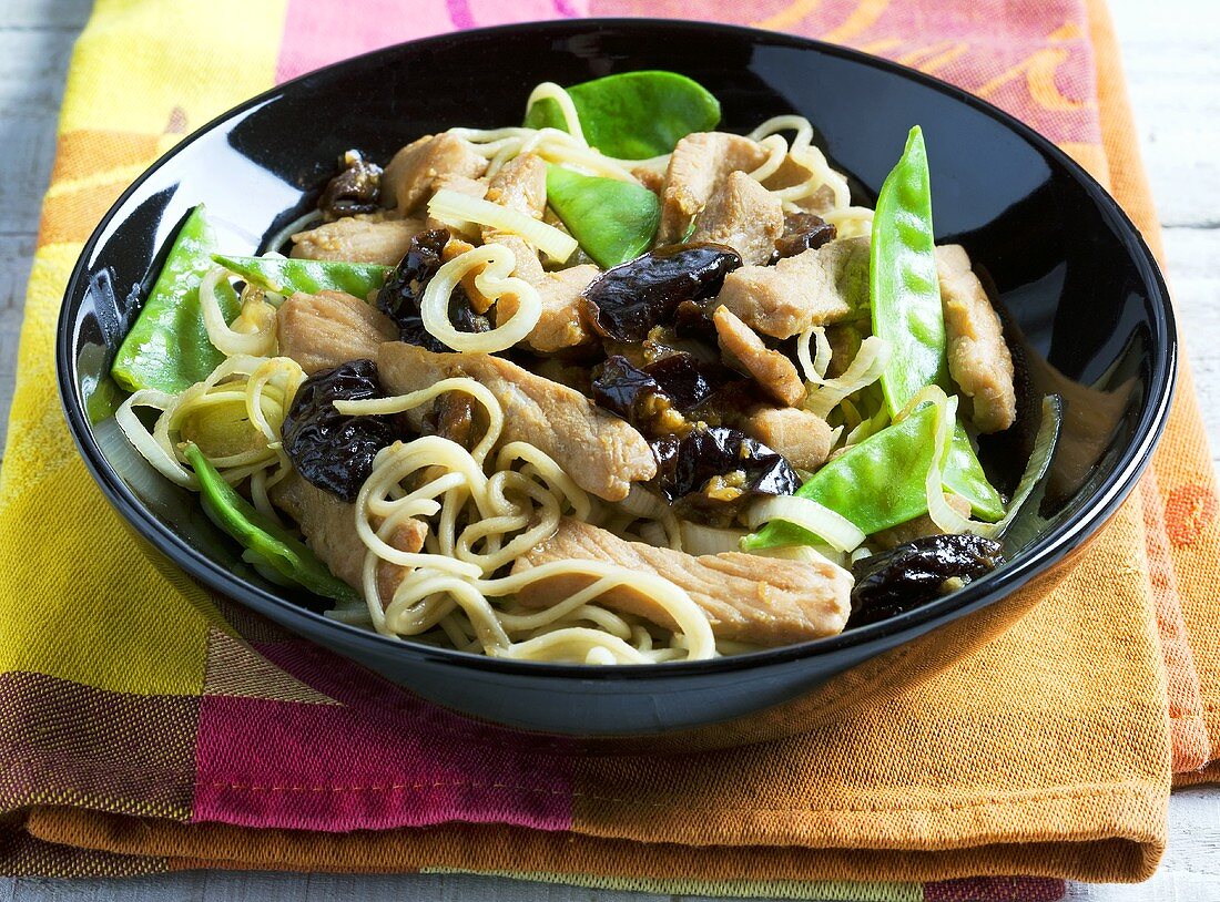 Schweinefleisch mit Trockenpflaumen, Nudeln und Zuckerschoten (Asien)